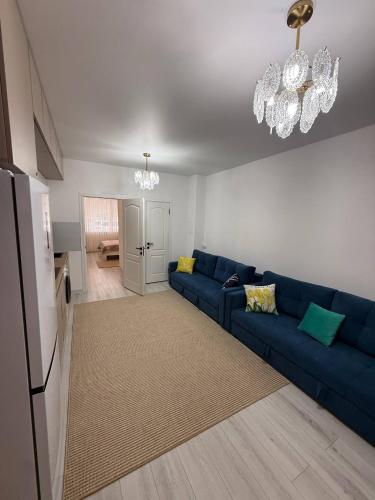 a living room with a blue couch and a kitchen at Wings Zen in Bosteri