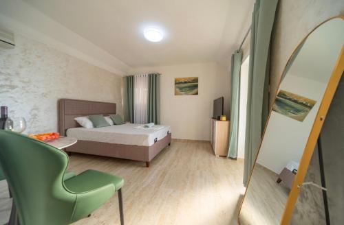 a bedroom with a bed and a green chair at The Best Lake View Studios Borisic in Vranjina
