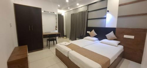 a bedroom with a bed and a desk in it at Aashi's Inn in Alleppey
