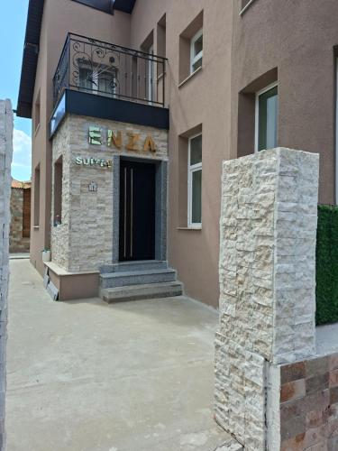 a building with a sign on the front of it at Enza Suites in Shumen