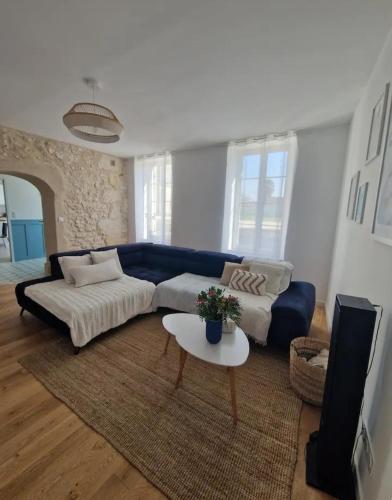 a living room with a blue couch and a table at Suite privée charentaise in Romegoux
