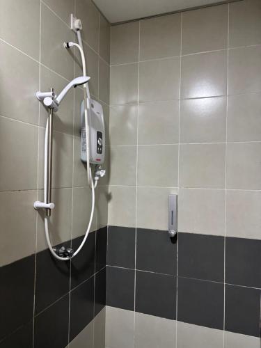 a shower in a bathroom with black and white tiles at Yunis Cottage Tranquil mountain views Centrum Cameron Highlands in Brinchang