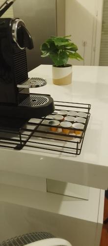 a desk with a laptop and cupcakes on a rack at ORCHIDÉES CHOISY 5Pers Parking Wifi in Choisy-le-Roi