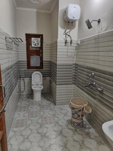 a bathroom with a toilet and a sink at Agyatvaas in Bhīm Tāl