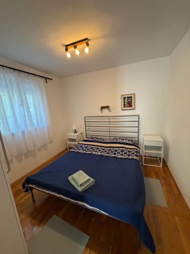 a bedroom with a bed with a blue blanket at Apartments Crnko, 50m from the beach with free parking and drinkable tap water in Vir
