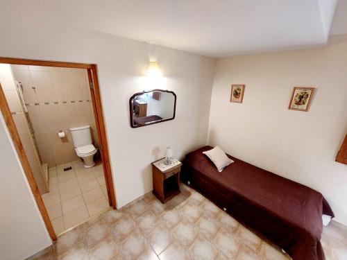 a small room with a bed and a bathroom at La Querencia de Buenos Aires in Buenos Aires