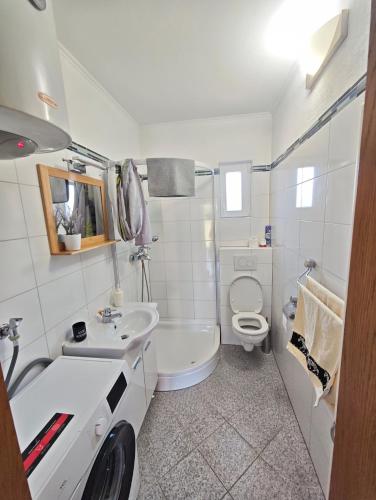 a white bathroom with a sink and a toilet at Kuća za odmor Bella in Sotin