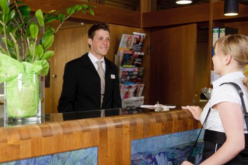 a man standing at a counter talking to a woman at Ringhotel Gasthof Hasen in Herrenberg