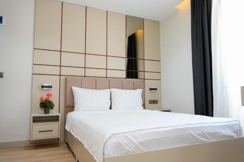 a bedroom with a large bed with white sheets at Nergiz Boutique Hotel in Antalya