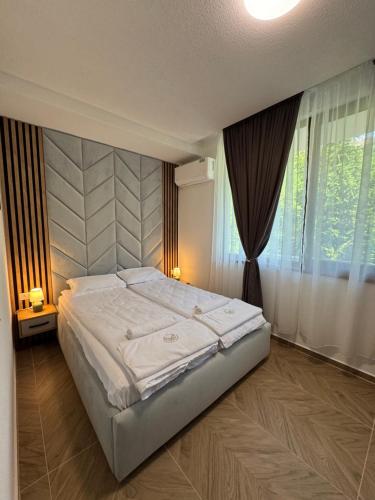 a bedroom with a large bed and a window at Комплекс Ванката in Kamena