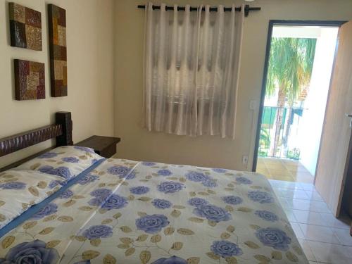 a bedroom with a bed with a blue and white comforter at Pousada Recanto Penedo in Penedo