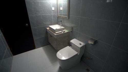 a bathroom with a toilet and a sink and a mirror at The Swiss Hotel & Resort in Cox's Bazar