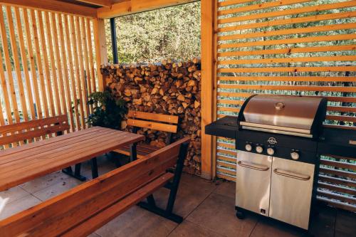 a grill and a table and a bench on a patio at Strefa ciszy Lubomin in Lubomin