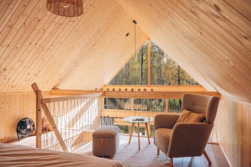 a room with a bed and two chairs and a window at Strefa ciszy Lubomin in Lubomin