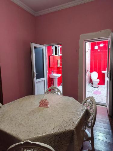 a dining room with a table and a bathroom at Cozy home in Zugdidi