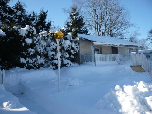 a yard covered in snow with a pole in front of a house at U Myslivce in Stein Schönau