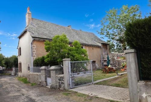 an old house with a gate in front of it at Le Refuge de l'Argence in Alpuech