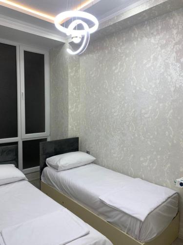 ein Zimmer mit zwei Betten und einem Kronleuchter in der Unterkunft Террас 5 in Astara