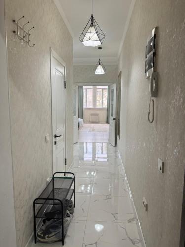 a hallway with a white tile floor and a room at Asia Street in Bishkek