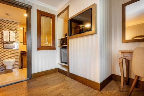 a bathroom with a toilet and a television on a wall at The central hotel in Istanbul