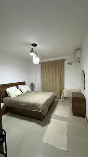 a bedroom with a large bed and a table at Blumar El Sokhna in Ain Sokhna