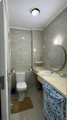 a bathroom with a toilet and a sink and a mirror at Blumar El Sokhna in Ain Sokhna