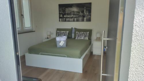 a small bedroom with a bed with green sheets and pillows at Bobbio Relax in Bobbio