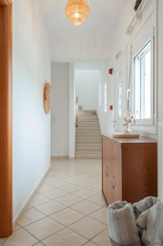 a hallway with white walls and a staircase in a house at Sunset Villa Amelia Skiathos in Skiathos National Airport