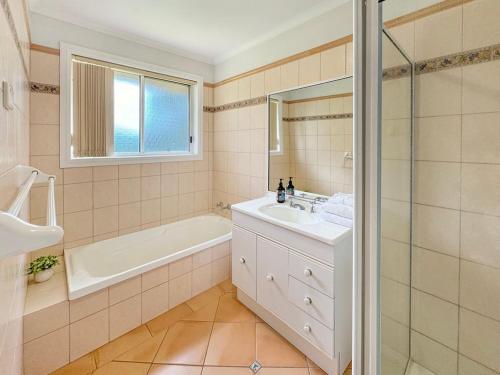 a bathroom with a tub and a sink and a shower at Suburban Bliss - Elegant Villa 2 in Wagga Wagga