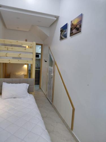 a bedroom with a white bed and a staircase at Studio cozy 04 in Tangier