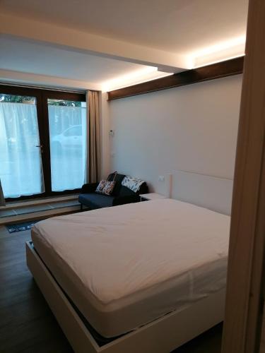 a bedroom with a bed and a chair and windows at Il Grottino in Frontino