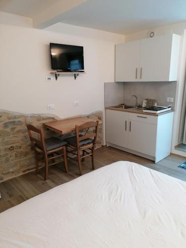 a living room with a table and a kitchen at Il Grottino in Frontino
