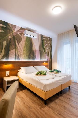 ein Schlafzimmer mit einem Bett und einem Gemälde an der Wand in der Unterkunft Hotel Antoniana in Caorle