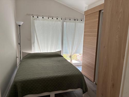 a bedroom with a bed in front of a window at Maisonnette in Arès