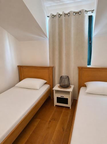 a bedroom with two beds and a nightstand between them at Novia Apartment 22 in Đenovići