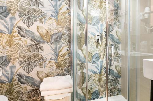 ein Badezimmer mit Dusche und blau-goldener Tapete in der Unterkunft Hotel Antoniana in Caorle