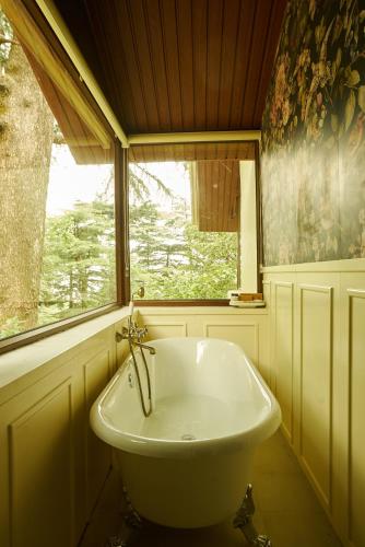a white sink in a bathroom with a window at MONKEY RESORT in McLeod Ganj