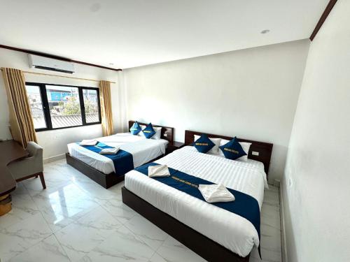 a hotel room with two beds and a window at BON Premier Boutique Hotel in Vang Vieng