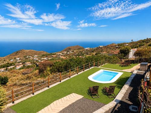 a yard with a swimming pool and chairs and the ocean at Celeste in Mazo