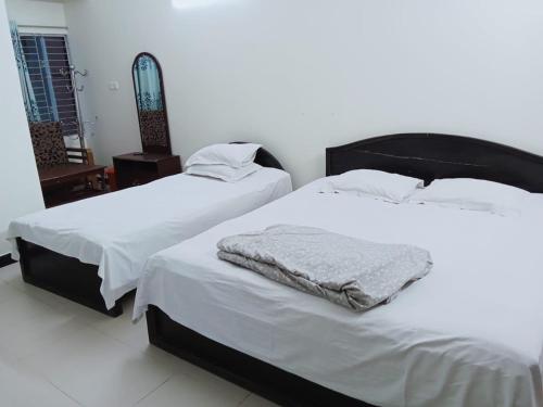 two beds sitting next to each other in a room at Rifaee Cox Palace in Cox's Bazar
