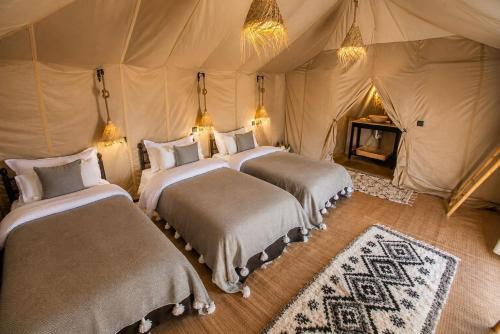 a bedroom with two beds in a tent at Merzouga Luxury Tents & Activities in Merzouga