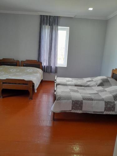 a bedroom with two beds and a window at Guest house Tea in Kvareli