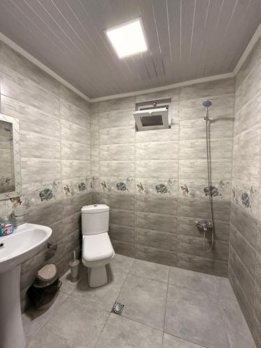 a bathroom with a toilet and a sink and a shower at Vacation Home Nukri in Gonio