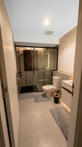 a bathroom with a toilet and a shower and a sink at 3BDS Luxury Stay Apartment - شقة 3 غرف للإقامة الفاخرة in Jeddah