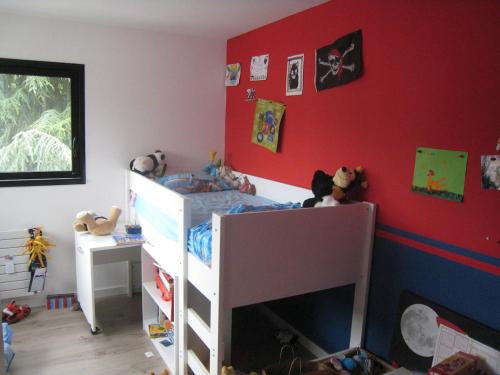 a bedroom with a bunk bed and red walls at Villa proche de Bordeaux in Gradignan