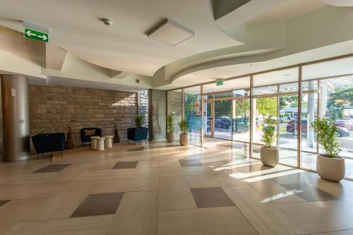 an empty lobby with potted plants in a building at Hotel Riviera in Mamaia