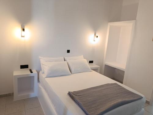 a white bed in a room with two lights at Anastasia in Aliko Beach