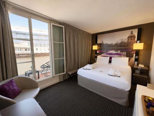 a hotel room with a large bed and a window at Mercure Toulouse Centre Wilson Capitole in Toulouse