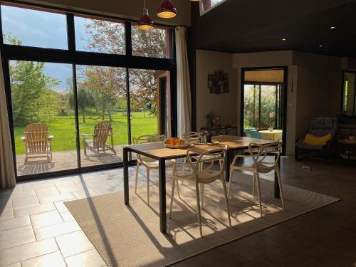 a dining room with a table and chairs and a large window at Le Domaine d'Elissois in Saint-Nicolas-de-Redon
