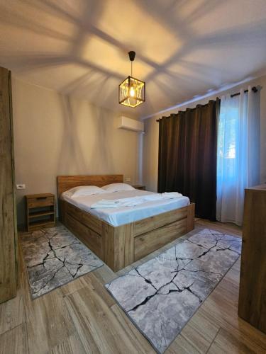 a bedroom with a bed and a chandelier at N'Shkoder in Shkodër